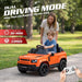 An orange children's ride-on toy car with black wheels and trim, shown outdoors on a paved path with a child sitting inside and an adult standing behind. Large text at the top reads 'DUAL DRIVING MODE,' with feature callouts on the left and a white remote in hand at the bottom right. Land Rover Defender 110 ride-on car with pedal mode and parental remote control