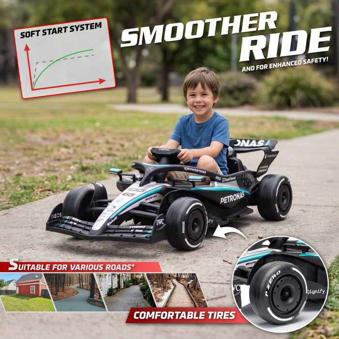 Mercedes-AMG F1 W16 24V lithium kids ride-on race car front three-quarter view A young boy driving a black and teal Mercedes F1-style electric ride-on toy car on a paved path in a park. The image includes promotional text overlays highlighting features like the 'Soft Start System', 'Smoother Ride', and 'Comfortable Tires', along with a close-up inset of the tire.