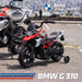 Children's motorcycle with BMW branding on a road.